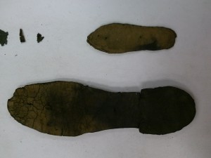 This is a baby shoe found in the Ronson collection. There was a plethora of shoe leather found in the hull of the Ronson. The larger shoe is in the picture for size comparison. The larger shoe is probably an adult male shoe.