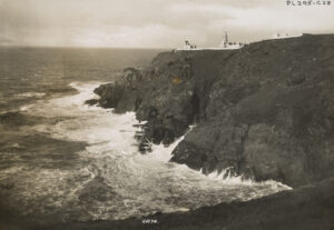 看着陡峭的岩石海岸线朝着灯塔。