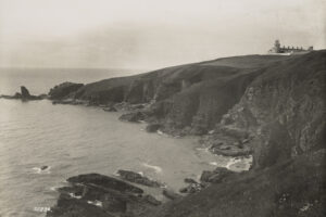 宽阔的海岸线景观，远处有灯塔。